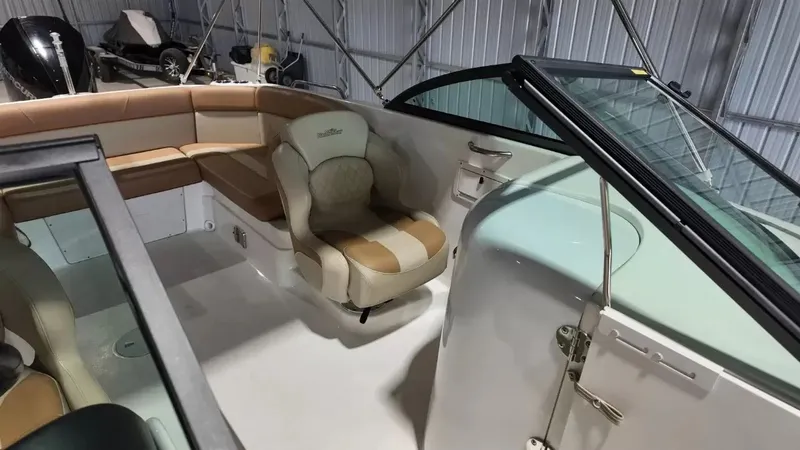 Slide: The Image of The image shows the cockpit of a 2023 NauticStar 243 DC with beige seating. - 42