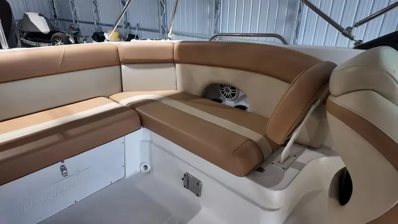 Slide: The Image of The image shows the seating area of a 2023 NauticStar 243 DC boat with beige upholstery. - 48