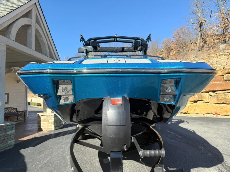 Slide: The Image of A blue Centurion Fe22 boat on a trailer, parked in front of a building. - 5