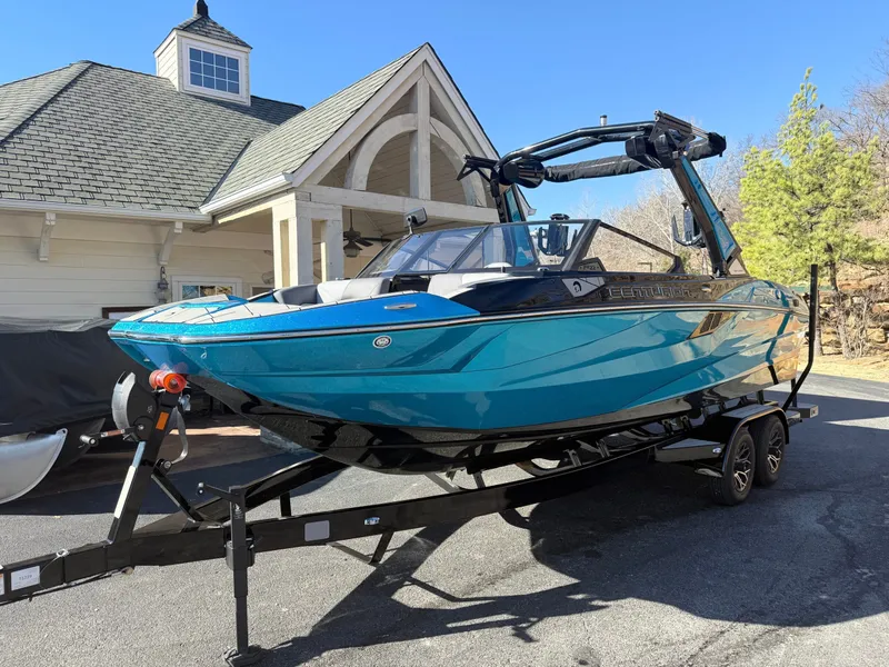 Slide: The Image of A 2026 Centurion Fe22 boat on a trailer in front of a house. - 2