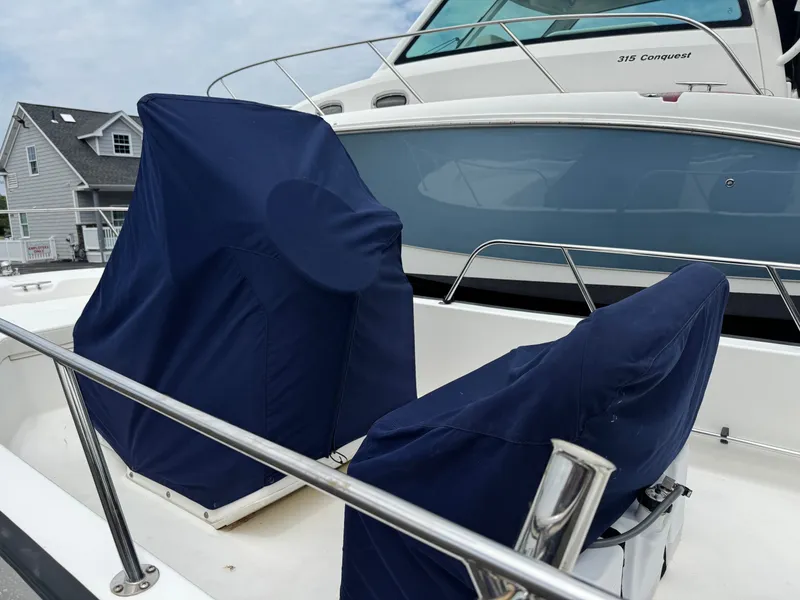 Slide: The Image of Two seats covered with blue fabric on a boat, with a larger boat in the background. - 7