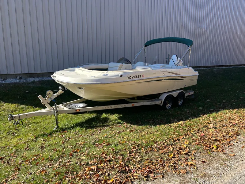 Slide: The Image of A 2003 Bennington RL210 boat on a trailer beside a building. - 3