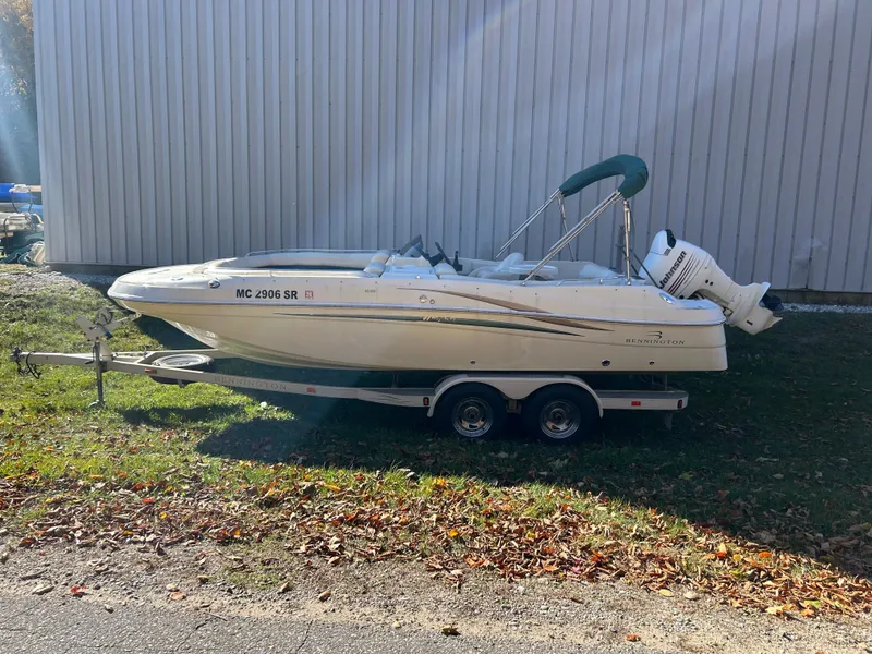 Slide: The Image of A 2003 Bennington RL210 boat on a trailer beside a building. - 7