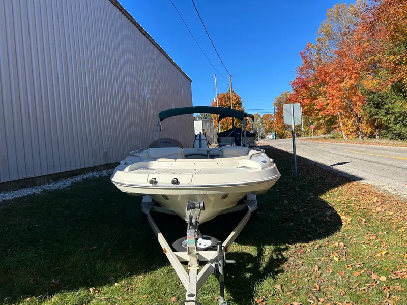 Slide: The Image of A 2003 Bennington RL210 on a trailer beside a building. Autumn trees in the background. - 4