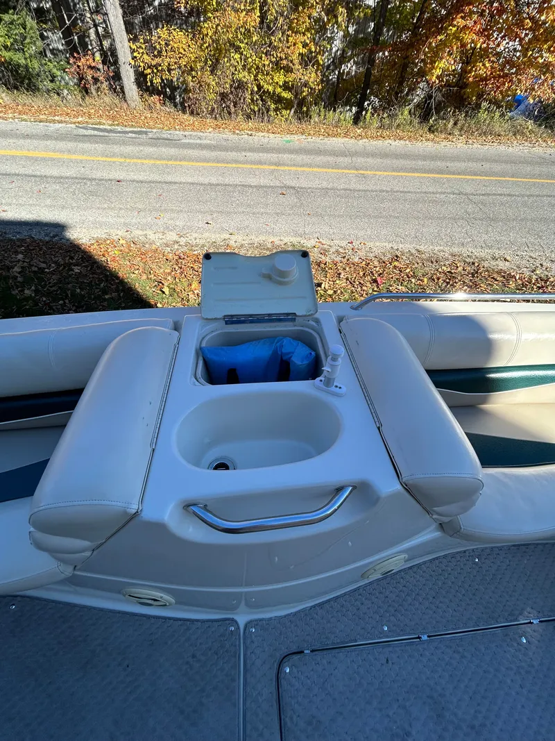 Slide: The Image of The image shows the cockpit of a Bennington RL210 boat with beige seats and a sink. - 10
