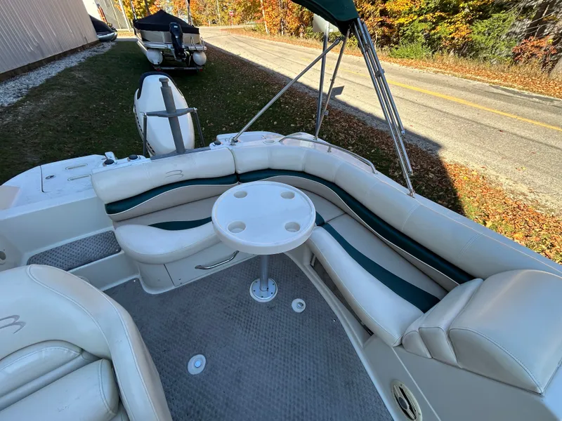 Slide: The Image of The image shows the cockpit of a 2003 Bennington RL210 with curved seating and a round table. - 11