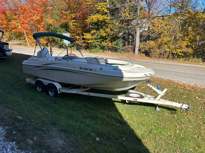 Slide: The Image of A 2003 Bennington RL210 boat on a trailer beside a road in autumn. - 2