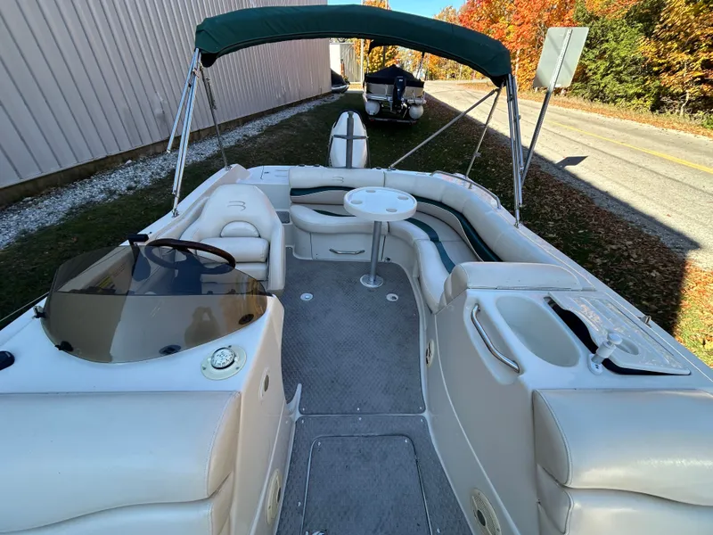 Slide: The Image of The image shows a 2003 Bennington RL210 pontoon boat with a green sunshade. - 9
