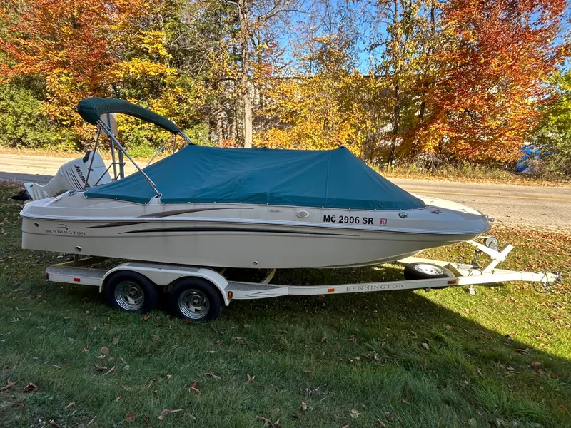 Slide: The Image of A 2003 Bennington RL210 boat on a trailer, surrounded by autumn trees. - 13
