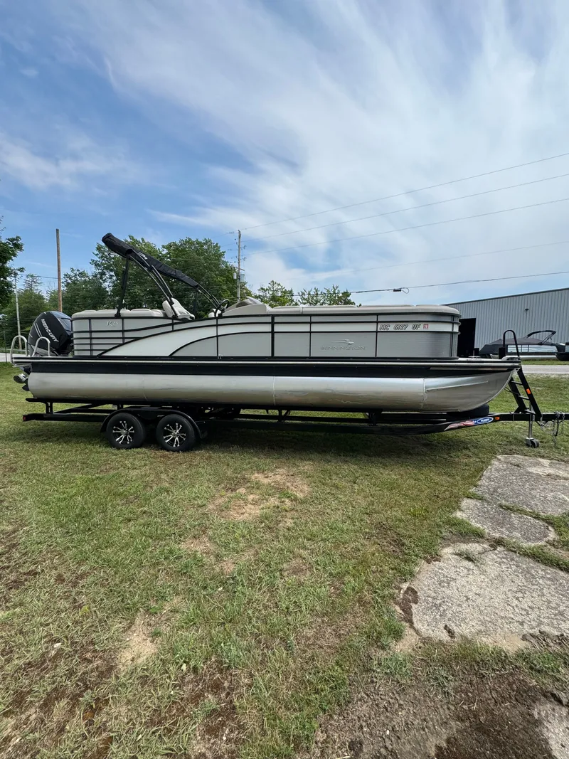 Slide: The Image of A 2019 Bennington 25RSR pontoon boat on a trailer, situated on grass. - 4