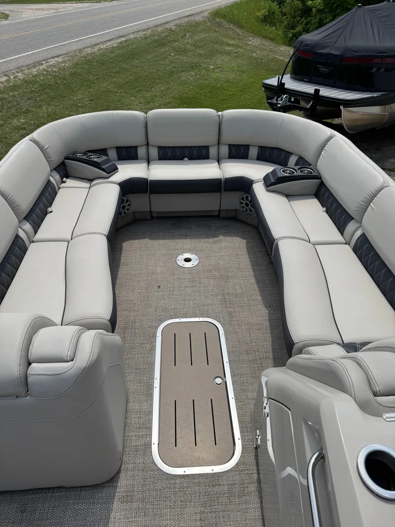 Slide: The Image of Interior view of a Bennington 25RSR pontoon boat with beige upholstery and carpeted flooring. - 7