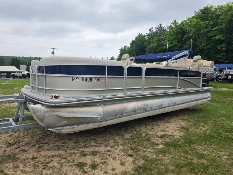 The Image of A 2012 Berkshire 231RF pontoon boat on a trailer in a grassy area. - 1