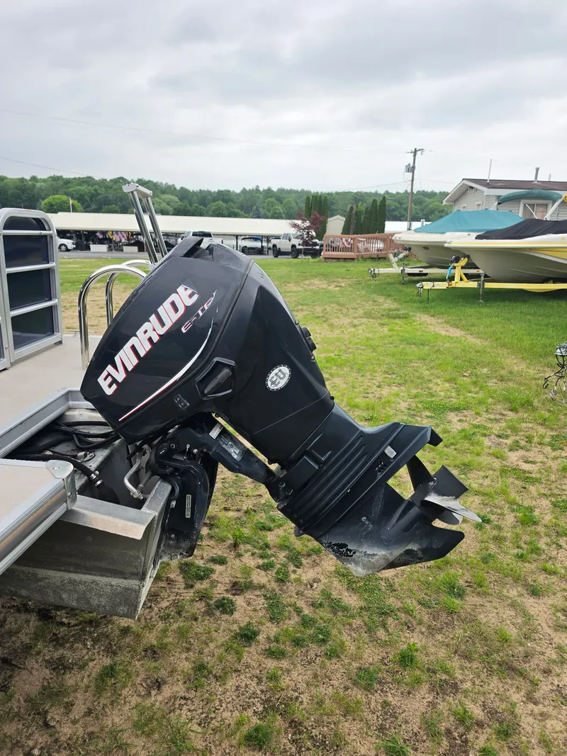 Slide: The Image of An Evinrude outboard motor is attached to a pontoon boat on a grassy area. - 3