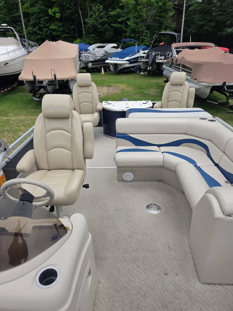Slide: The Image of The image shows the interior of a 2012 Berkshire 231RF pontoon boat with beige seating. - 10