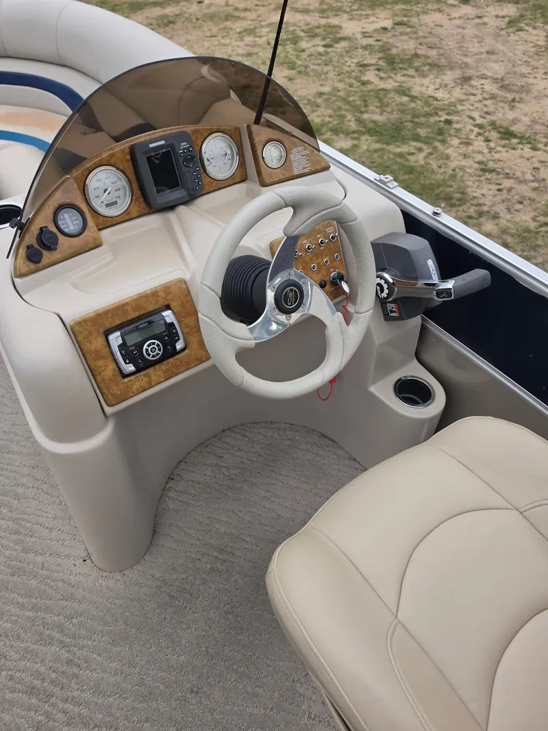 Slide: The Image of The image shows the helm of a 2012 Berkshire 231RF with cream seats and wood accents. - 8