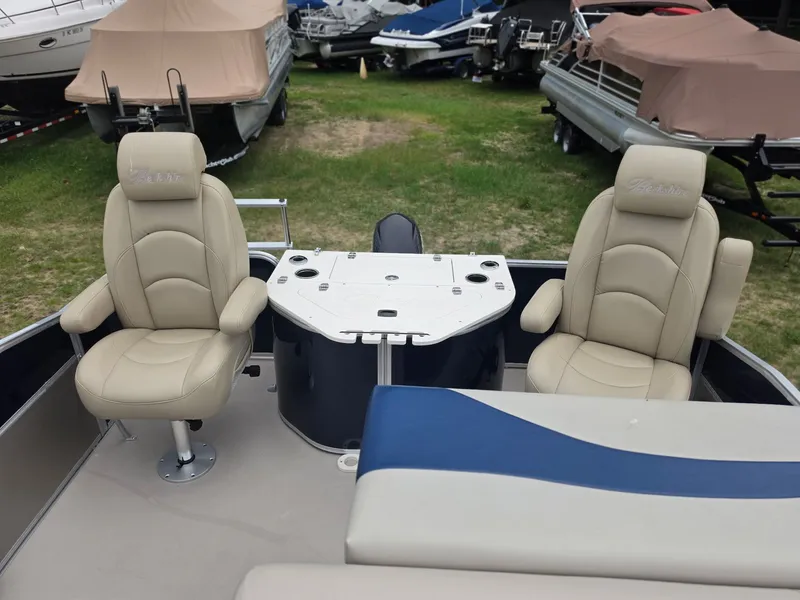 Slide: The Image of Two beige captain's chairs on a pontoon boat with a table in between. - 11