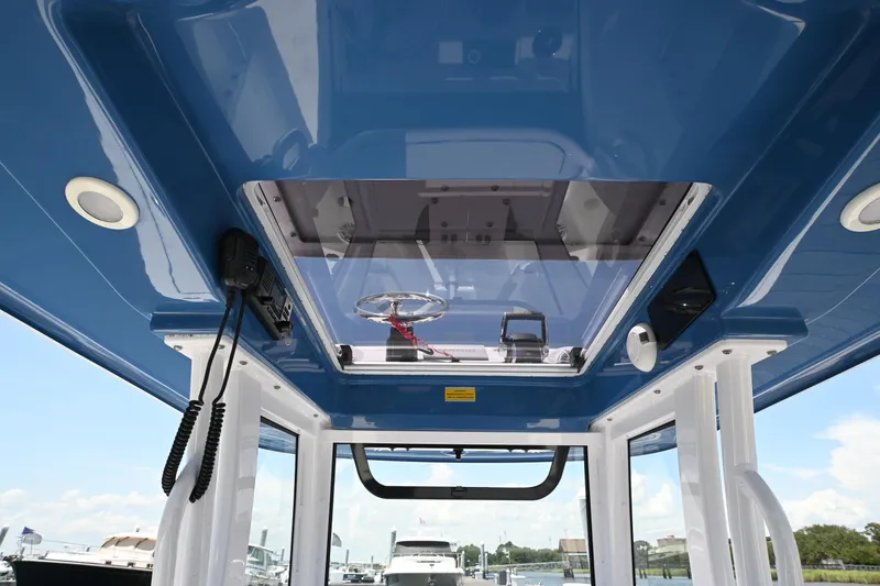 Slide: The Image of 2025 Sportsman Heritage 261 Center Console boat interior with blue ceiling and skylight. - 8