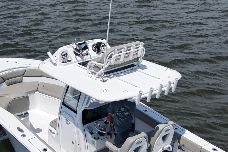 Slide: The Image of 2025 Sportsman Heritage 261 Center Console boat cruising on water, featuring spacious seating and modern controls. - 2