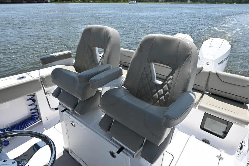 Slide: The Image of 2025 Sportsman Heritage 261 Center Console boat with luxurious seating on a calm water backdrop. - 19