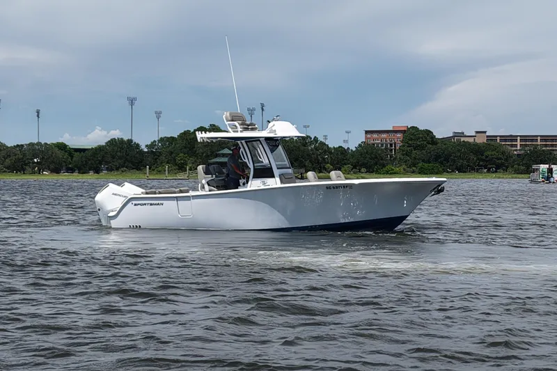 Slide: The Image of 2025 Sportsman Heritage 261 Center Console boat cruising on a calm lake. - 5