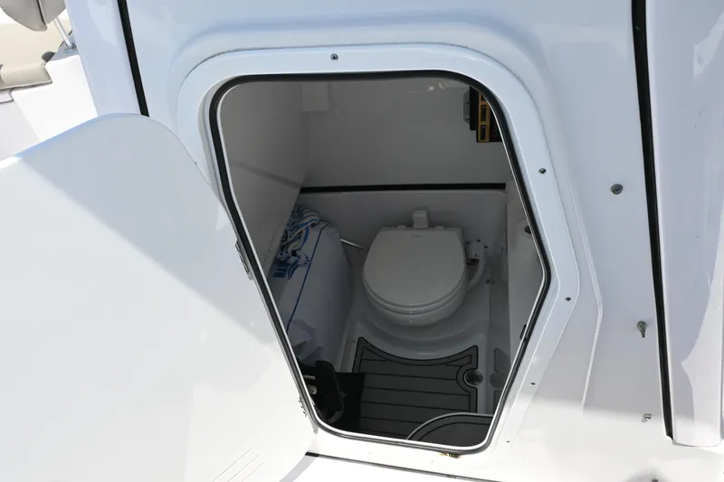 Slide: The Image of 2025 Sportsman Heritage 261 Center Console boat interior with compact marine toilet. - 27