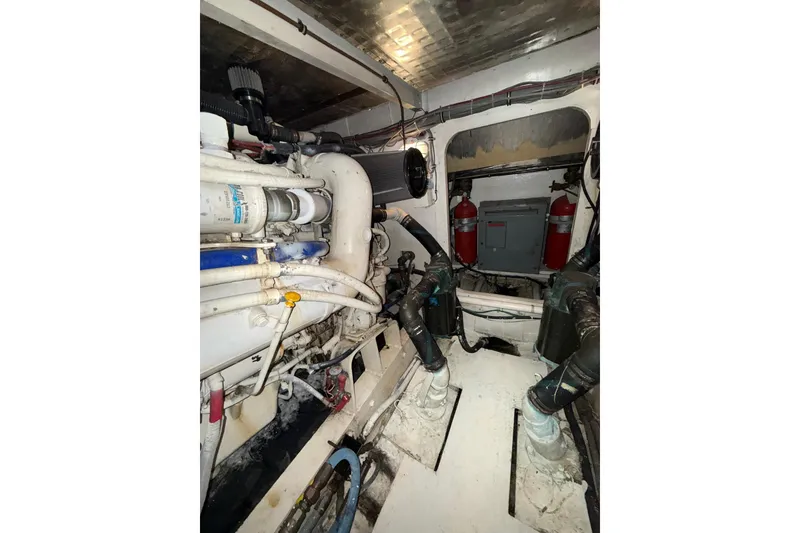 Slide: The Image of Engine room of a 1989 Bertram 43 Convertible boat, showcasing mechanical components. - 61
