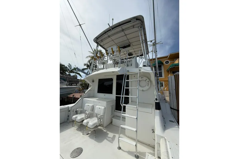 Slide: The Image of 1989 Bertram 43 Convertible yacht with ladder and seating, docked near palm trees. - 21
