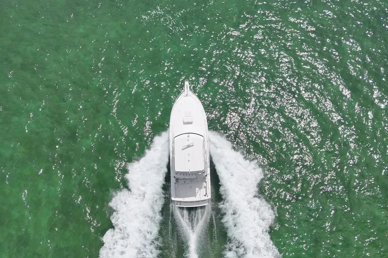 Slide: The Image of Aerial view of 1989 Bertram 43 Convertible yacht cruising on vibrant green water. - 6