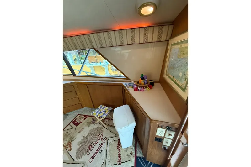 Slide: The Image of Interior of 1989 Bertram 43 Convertible yacht with map, decor, and seating. - 35