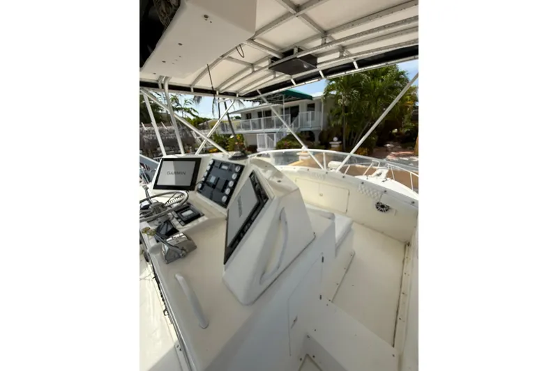 Slide: The Image of 1989 Bertram 43 Convertible boat cockpit with modern navigation equipment and tropical background. - 52