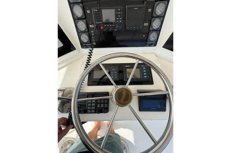 Slide: The Image of Control panel of a 1989 Bertram 43 Convertible boat with steering wheel and navigation instruments. - 51