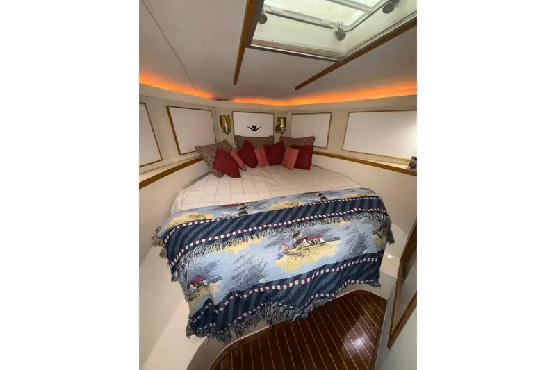 Slide: The Image of Cozy cabin interior of 1989 Bertram 43 Convertible with decorative bedding and ambient lighting. - 44