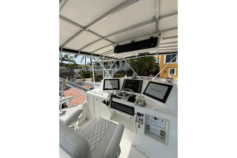 Slide: The Image of 1989 Bertram 43 Convertible yacht helm with Garmin navigation system and luxurious seating. - 48