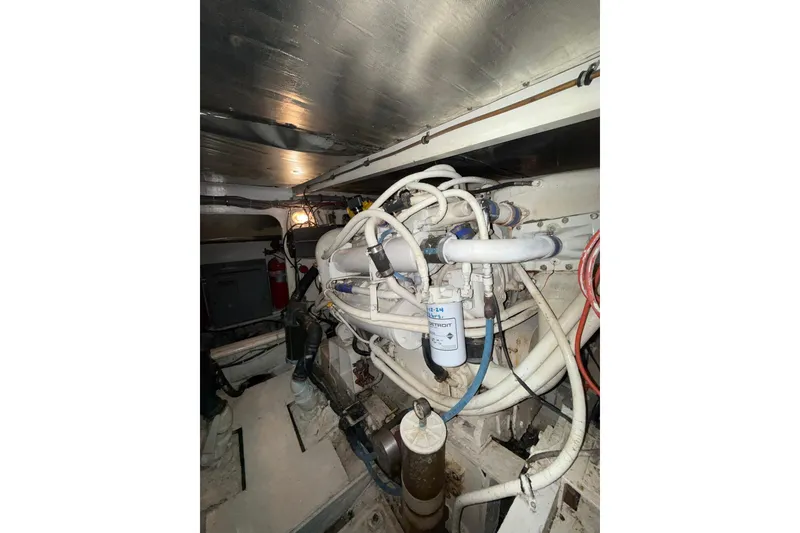 Slide: The Image of Engine room of a 1989 Bertram 43 Convertible with visible pipes and machinery. - 60