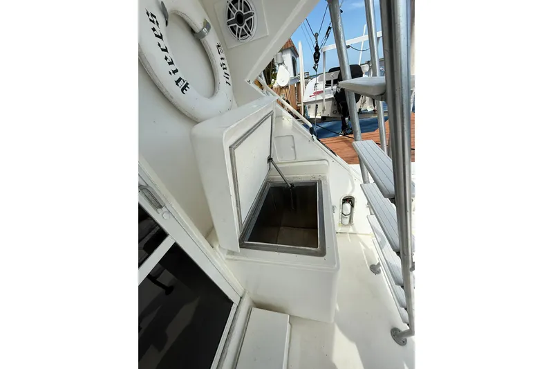 Slide: The Image of 1989 Bertram 43 Convertible boat deck with open storage compartment and life preserver. - 29