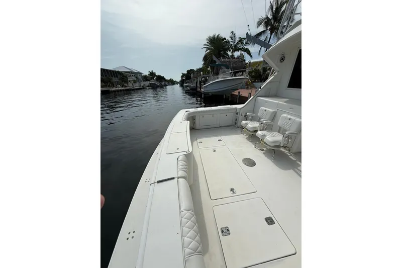 Slide: The Image of 1989 Bertram 43 Convertible yacht deck with seating, docked by a canal. - 20