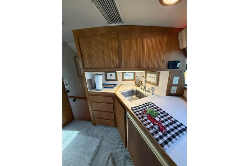 Slide: The Image of 1989 Bertram 43 Convertible yacht kitchen with wood cabinets and stainless steel sink. - 37