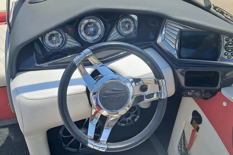 Slide: The Image of Interior dashboard of a 2013 Tigé RZ2 boat with chrome steering wheel and gauges. - 4