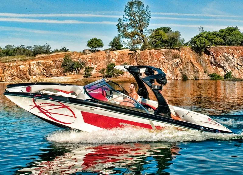 Slide: The Image of Manufacturer Provided Image: 2013 Tigé RZ2 boat cruising on a lake with rocky cliffs in the background. - 9