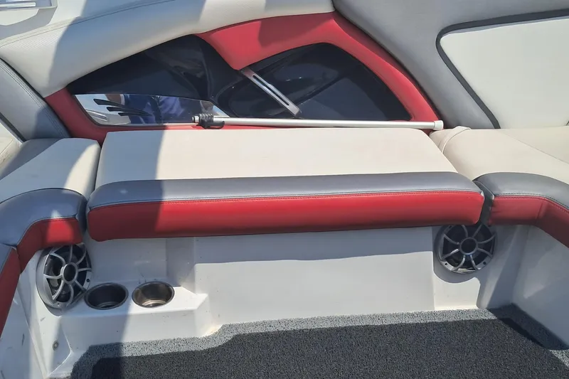 Slide: The Image of 2013 Tigé RZ2 boat interior with red and gray seating, cup holders, and speakers. - 5