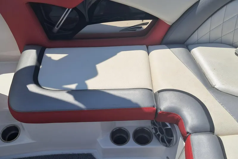 Slide: The Image of 2013 Tigé RZ2 boat interior with red and gray seating and cup holders. - 7