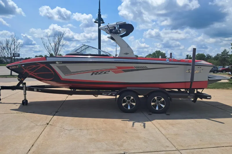 The Image of 2013 Tigé RZ2 boat on trailer under a partly cloudy sky. - 0