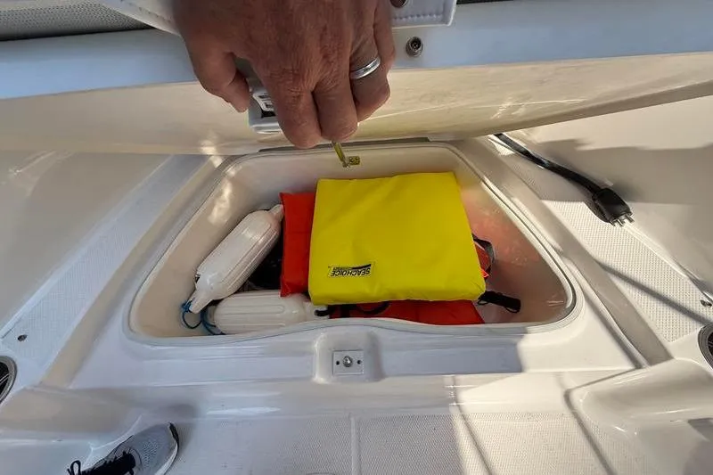 Slide: The Image of Storage compartment of 2022 Robalo R180 Center Console with safety gear and accessories. - 28