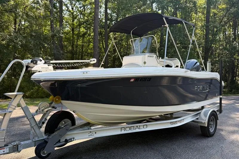 Slide: The Image of 2022 Robalo R180 Center Console boat on trailer in wooded area. - 7