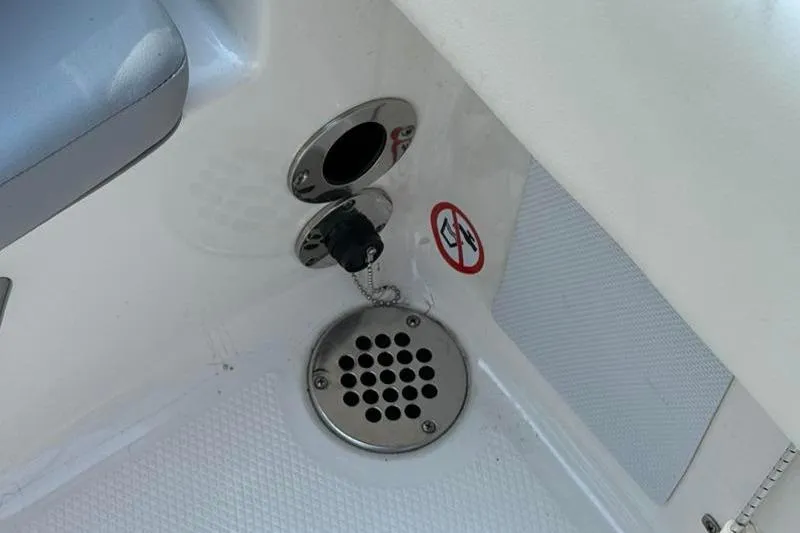 Slide: The Image of 2022 Robalo R180 Center Console boat detail with drainage and warning sign. - 15