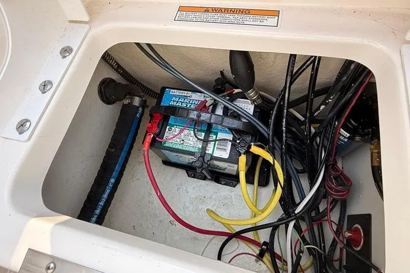 Slide: The Image of Battery compartment of 2022 Robalo R180 Center Console with wiring and marine battery. - 9