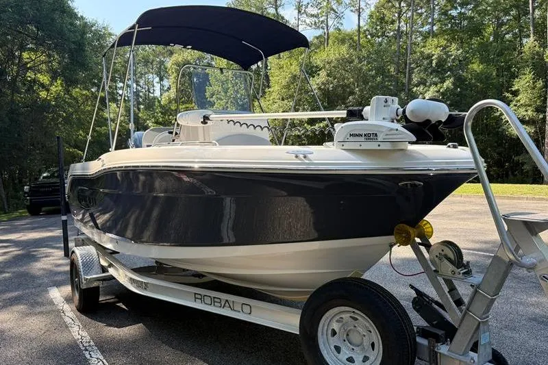 Slide: The Image of 2022 Robalo R180 Center Console boat on trailer in wooded area. - 6