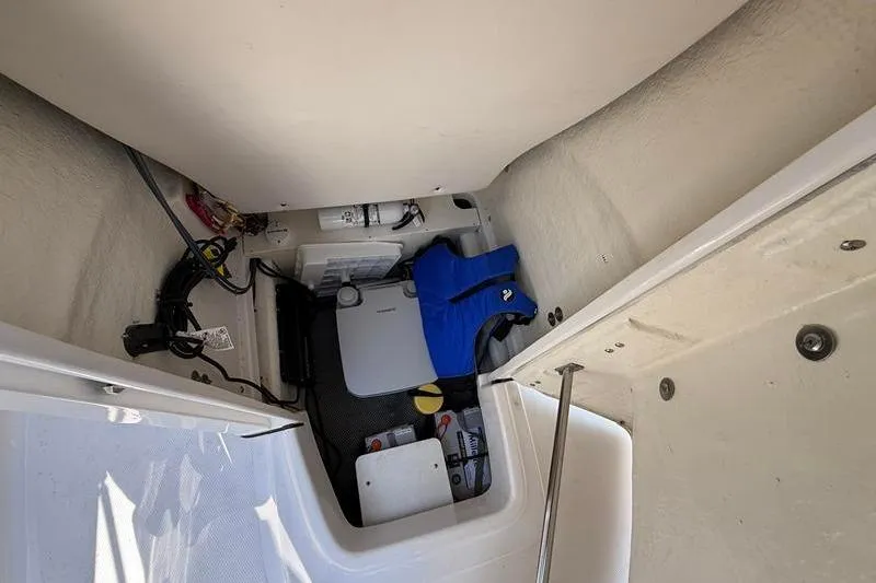 Slide: The Image of 2022 Robalo R180 Center Console storage area with life jacket and equipment. - 26