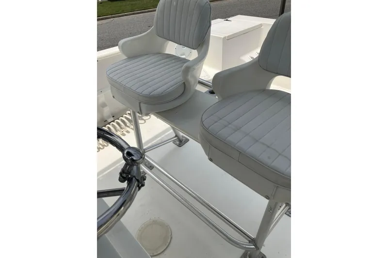 Slide: The Image of 2003 Seapro 239 boat interior with dual white cushioned seats and steering wheel. - 20