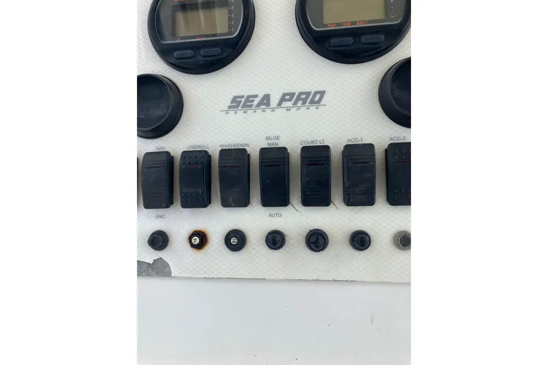 Slide: The Image of Control panel of a 2003 Seapro 239 boat with switches and gauges. - 6